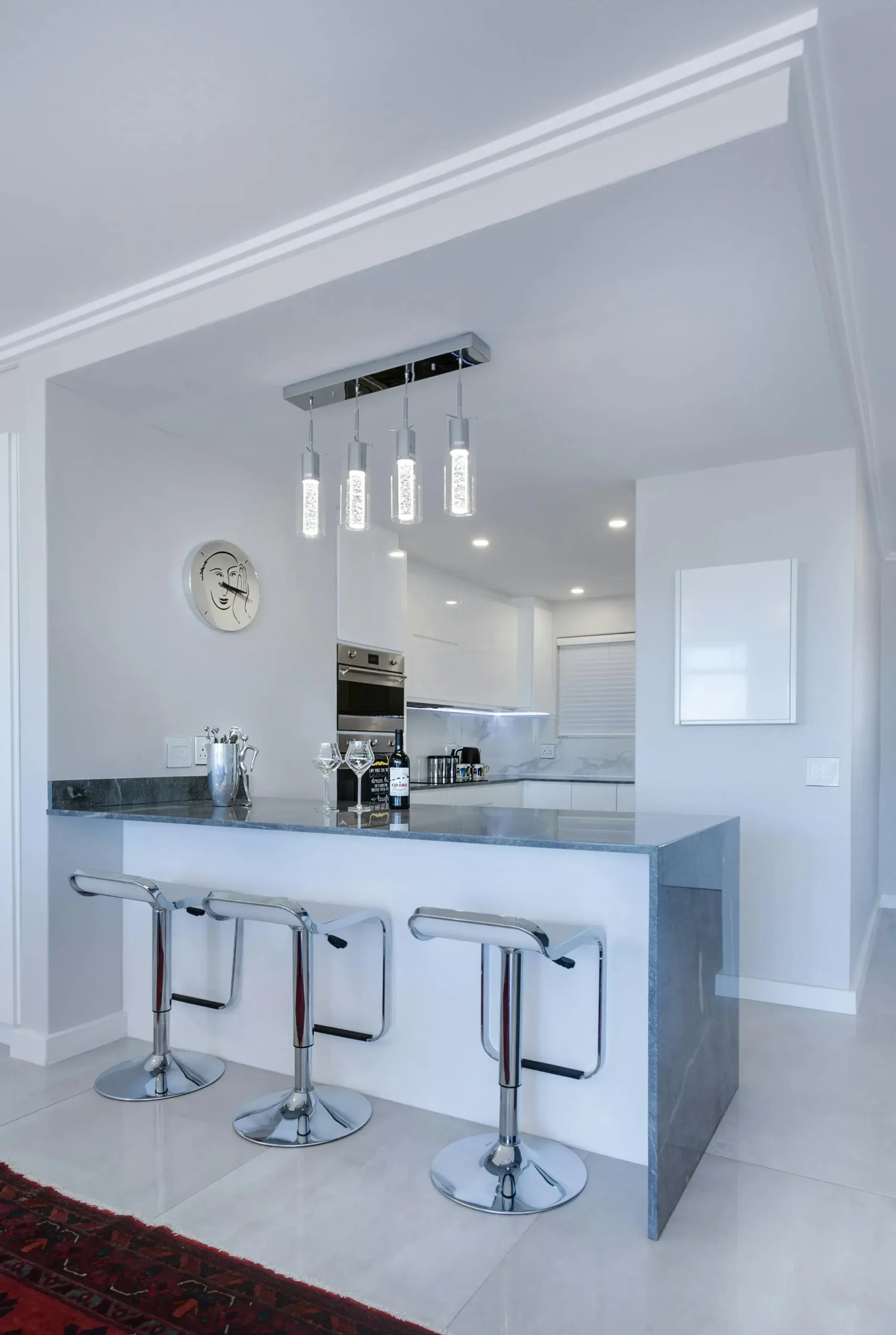 Modern and clean kitchen in San Francisco with stylish lighting and stainless steel bar stools